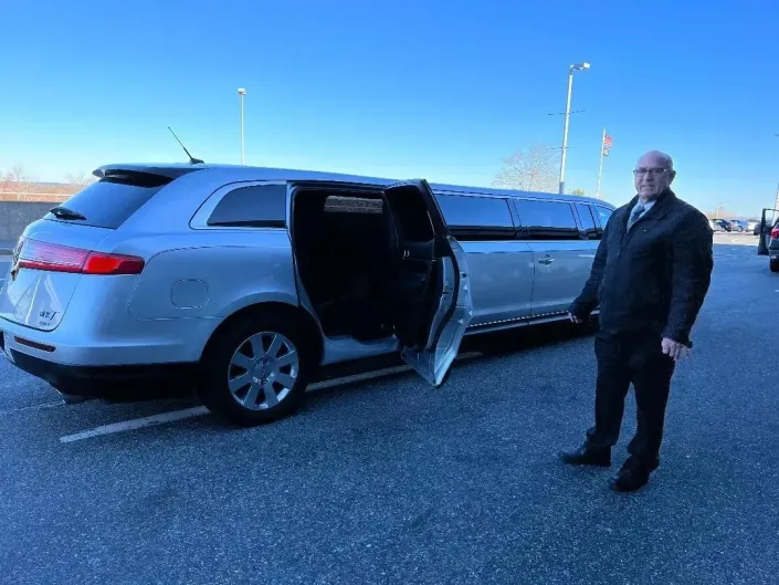 driver holding open limo door